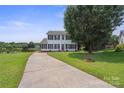Inviting two-story home with a long driveway and mature tree, situated lakeside at 6516 Laurel Springs Ct, Charlotte, NC 28227