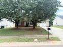 Cozy home with mature trees in the front yard and an extended driveway at 6902 Vernon Wood Ln, Charlotte, NC 28262