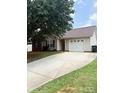 Well maintained home with an attached garage and a long driveway at 6902 Vernon Wood Ln, Charlotte, NC 28262