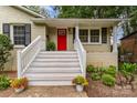 Inviting front porch with white railings and a bright red door at 6935 Woodstock Dr, Charlotte, NC 28210