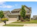 Traditional two-story home with green lawn, lush landscaping, and two car garage at 7263 Waterwheel Sw St, Concord, NC 28025
