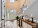 Bright foyer with tile flooring, a staircase, and stylish console table at 7810 Leisure Ln, Huntersville, NC 28078