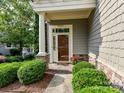 Inviting front entrance with stone accents, mature landscaping, and a covered porch at 8026 Greenview Terrace Ct, Charlotte, NC 28277
