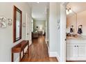 Bright hallway featuring hardwood floors and views into the adjacent living spaces and bath at 8026 Greenview Terrace Ct, Charlotte, NC 28277