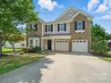 Lovely exterior of a two-story home featuring brick and siding, a two-car garage and green lawn at 8304 Prescott Glen Pkwy, Waxhaw, NC 28173