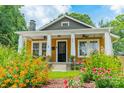 Inviting mustard-color home exterior surrounded by blooming flowers at 904 Anderson St, Charlotte, NC 28205