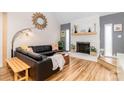 Cozy living room with a stone fireplace, hardwood floors, and a comfortable leather sofa at 10209 Green Tee Ln, Charlotte, NC 28277