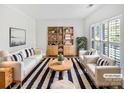 Bright living room with stylish furnishings, a striped rug, and built in shelving with natural plants at 1090 Mclaren Dr, Belmont, NC 28012