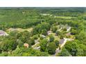 An aerial view shows the home nestled in a neighborhood surrounded by mature trees and lush landscaping at 111 Kelly Ln, Gastonia, NC 28056