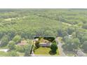 An aerial view highlights a single Gathering home and the surrounding wooded land included with the property at 111 Kelly Ln, Gastonia, NC 28056