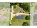 This aerial view shows the home, detached garage and a paved area adjacent to the extra long driveway at 111 Kelly Ln, Gastonia, NC 28056