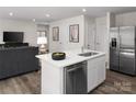 Open-concept living space with a stylish kitchen island, stainless steel appliances, modern finishes, and a comfortable living area at 1202 Elm Forest Ln, China Grove, NC 28023