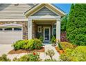 Inviting front porch with decorative plants and stone accents on the home's exterior create an inviting entrance at 1313 Haywood Park Rd, Marvin, NC 28173