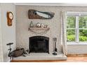 Close-up of the brick fireplace with decorative mantel and hearth, accented by wood floors at 151 Cynthia St, Statesville, NC 28677
