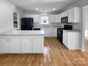 Modern kitchen featuring white cabinets, black appliances, and a breakfast bar at 1573 Maypine Commons Way, Rock Hill, SC 29732