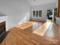 Bright living room with hardwood floors, a cozy fireplace, and a large window providing natural light at 1573 Maypine Commons Way, Rock Hill, SC 29732