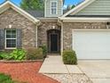 Inviting entryway showcasing brick detailing, manicured bushes, and a well-maintained front yard at 1660 Beleek Ridge Ln, Lake Wylie, SC 29710