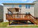 Close up of wooden deck with pergola and stairs leading to grassy backyard at 1680 Trentwood Dr, Fort Mill, SC 29715