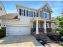 Charming two-story home featuring a covered front porch, attached garage and well-maintained landscaping at 1680 Trentwood Dr, Fort Mill, SC 29715