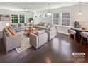 Bright and airy living room featuring hardwood floors, neutral furniture, and abundant natural light at 1680 Trentwood Dr, Fort Mill, SC 29715