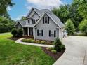 Well-maintained home with gray siding, black shutters, and professional landscaping at 175 Turnberry Ln, Mooresville, NC 28117