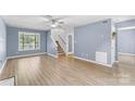 Inviting living room with light blue walls, wood floors, a ceiling fan, and a staircase at 176 Sharon Valley Dr, Hickory, NC 28601