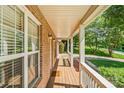 Covered front porch showcasing brick exterior with white columns and a wooden floor at 176 Sharon Valley Dr, Hickory, NC 28601