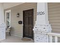 Inviting front porch featuring a dark wood door with decorative columns and visible house number at 1826 Hall Ave, Charlotte, NC 28205