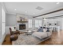 Open-concept living room with stone fireplace, wood beams, hardwood floors, and seamless flow to the kitchen at 1826 Hall Ave, Charlotte, NC 28205