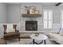 Bright living room featuring a stone fireplace with a wooden mantel, hardwood floors, and comfortable seating at 1826 Hall Ave, Charlotte, NC 28205