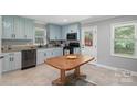 Bright kitchen featuring blue cabinets, modern appliances, and a dining table at 2131 Lee St, Gastonia, NC 28054