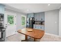 Sunlit kitchen showcasing blue cabinets, stainless steel appliances, and a dining table at 2131 Lee St, Gastonia, NC 28054