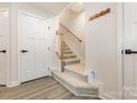 Bright entryway featuring carpeted stairs with wooden banister and coat rack at 2203 Autumn Olive Ln, Stallings, NC 28104