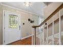 Bright foyer with hardwood floors, a staircase, decorative wall art, and a patterned glass front door at 2525 Saddlehorse Ln, Gastonia, NC 28056