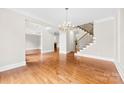 Spacious living room featuring hardwood floors, staircase and chandelier, perfect for entertaining at 2857 Scarborough Ct, Gastonia, NC 28054