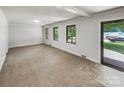 Bright living room with three large windows and a glass door to the right, showing outdoor views at 302 Melinda Ave, Kannapolis, NC 28083