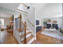 Inviting home foyer featuring hardwood stairs with iron railings and a view into the living room at 3800 Lovett Cir, Charlotte, NC 28210