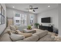 Inviting living room with sectional sofa, modern ceiling fan, and plenty of natural light at 5006 Tiny Ln, Charlotte, NC 28203