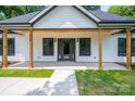 Close-up of the front porch featuring natural wood supports and black framed windows at 520 E Main St, Dallas, NC 28034