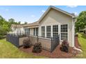 A back exterior view showcasing a fenced deck with a retractable awning and lush, private landscaping at 56119 Finches Ct, Indian Land, SC 29707