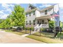 Well-maintained home showcasing a black metal fence, mature tree, a small lawn, and landscaped garden beds at 635 R L Stowe Rd, Belmont, NC 28012