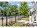Exterior view showcasing a black metal fence, a small front lawn, mature trees, and a home's entrance at 635 R L Stowe Rd, Belmont, NC 28012