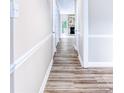 Hallway featuring wood floors that leads to the spacious living room with a stone fireplace at 7912 Charter Oak Ln, Charlotte, NC 28226