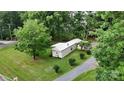 Aerial view of home with a detached garage and surrounded by mature shade trees at 8112 Blackwood Rd, Denver, NC 28037