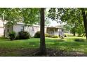 Exterior of home with a covered porch, green grass, and mature landscaping at 8112 Blackwood Rd, Denver, NC 28037