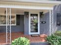 Charming front porch featuring a white brick wall, tiled floor, and stylish outdoor lighting at 848 Woodland Rd, Statesville, NC 28677