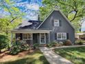 Charming gray home featuring a peaked roof, well-manicured lawn, and inviting front porch at 848 Woodland Rd, Statesville, NC 28677