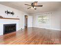 Bright living room features hardwood floors, a brick fireplace, and large window at 848 Woodland Rd, Statesville, NC 28677