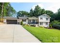 Attractive home showcasing a long driveway leading to an attached garage and well-maintained front yard at 932 Shady Bluff Dr, Charlotte, NC 28211