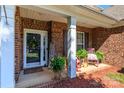 Inviting covered front porch with rocking chairs, greenery and brick facade at 1006 Apogee Dr, Indian Trail, NC 28079
